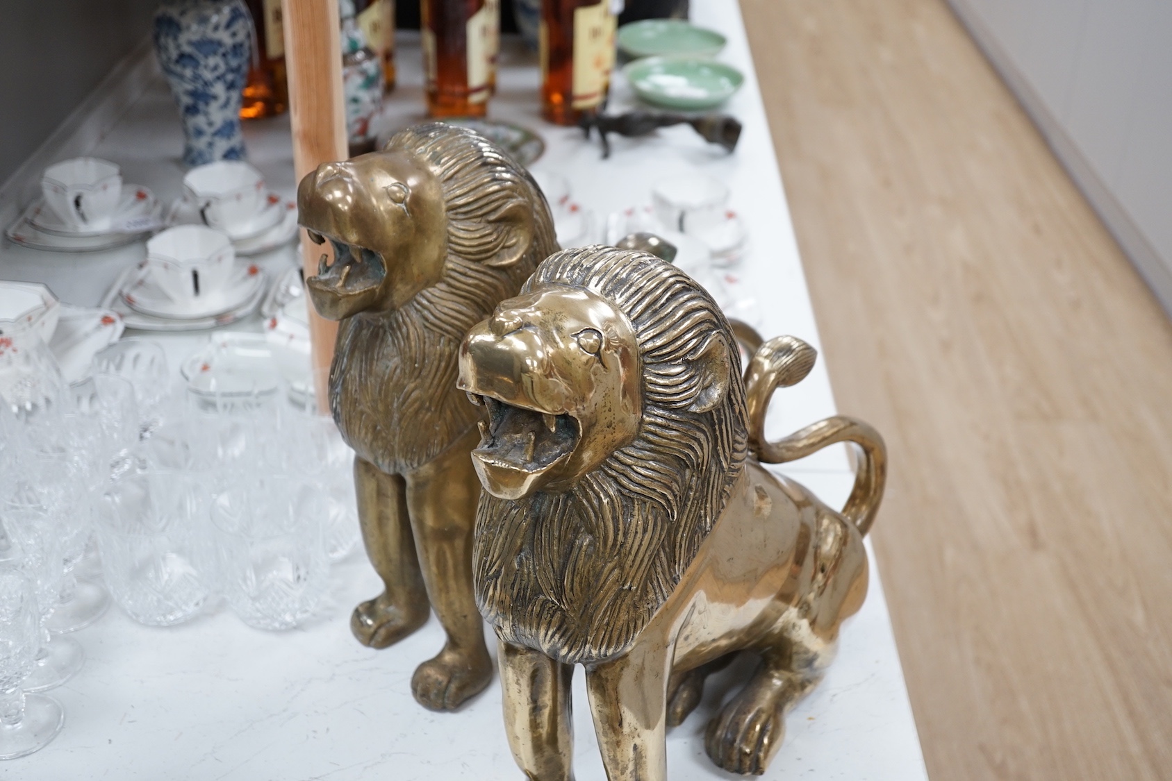 A pair of large brass lion models. 39cm